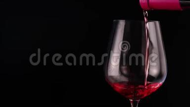 红酒从瓶子里倒进酒吧里的玻璃里。 黑色背景下的红酒